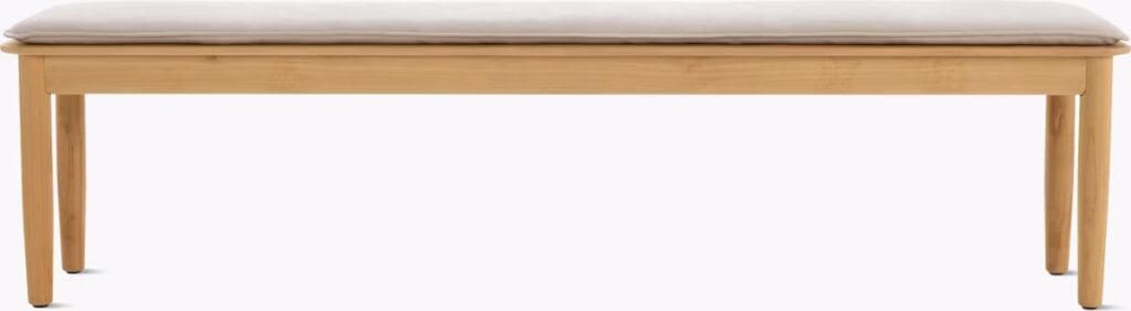 A minimalist wooden bench with a cushioned seat, featuring slender legs and a simple, modern design.