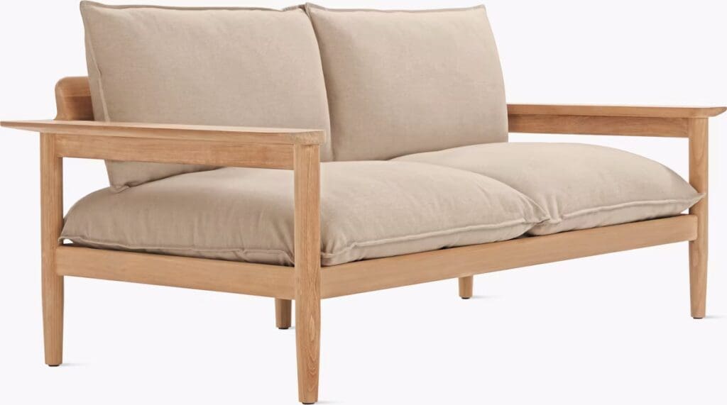 A modern sofa with a light beige upholstery and wooden frame, featuring plush cushions for comfort.