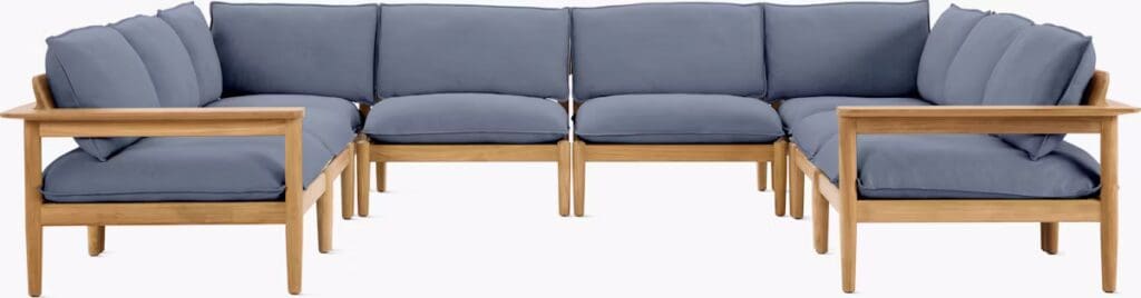 Modern outdoor sectional sofa with light blue cushions and wooden frame, arranged in a spacious layout.