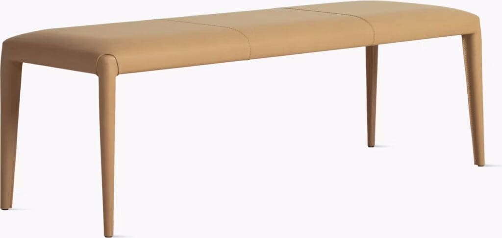 A modern tan leather bench with a sleek design featuring smooth lines and tapered legs.