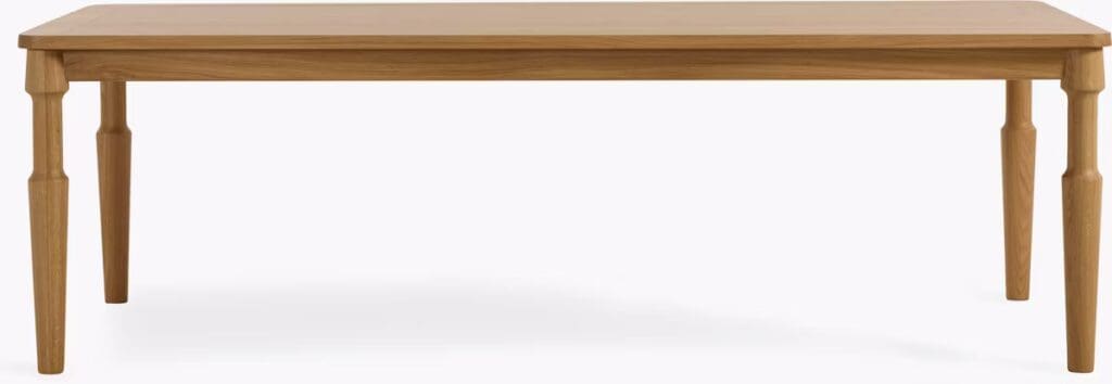 A wooden dining table with four tapered legs and a smooth rectangular surface.