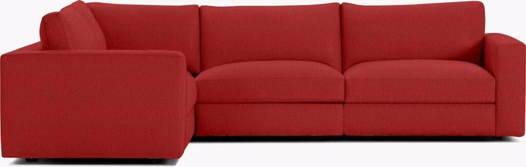Red sectional sofa with a modern design and plush cushions.