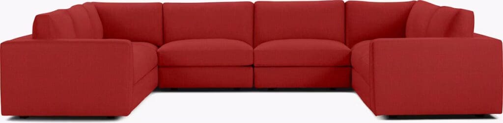 Red sectional sofa with a modern design, featuring a low back and thick cushions.