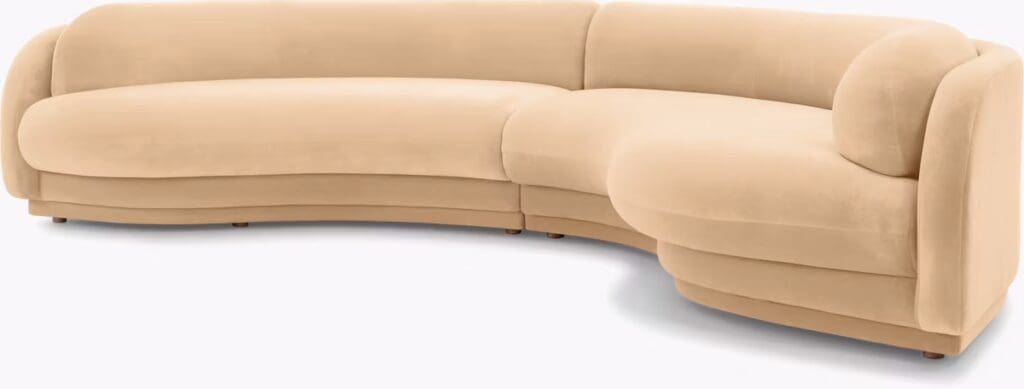 Beige curved sectional sofa with a smooth surface and soft edges.