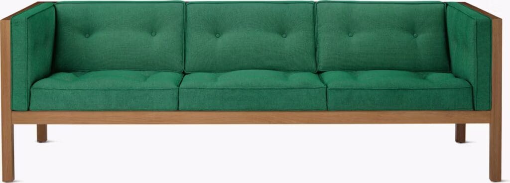 A modern green sofa with button-tufted cushions and a wooden frame, showcasing a minimalist design.