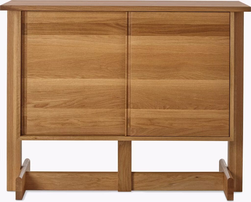 Wooden storage cabinet with sliding doors and a minimalist design.