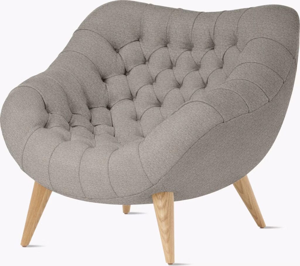 Tufted grey lounge chair with wooden legs, designed for comfort and style.