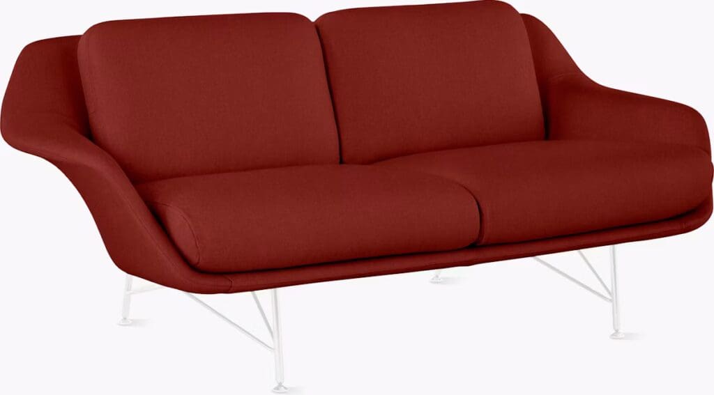 A stylish red sofa with a modern design, featuring a comfortable silhouette and white metal legs, ideal for contemporary living spaces.