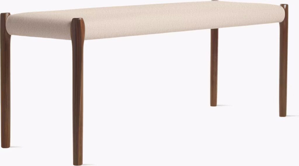 Modern bench with a beige upholstered seat and wooden legs.