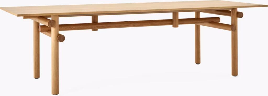 A modern wooden dining table with a simple design, featuring cylindrical legs and a clean rectangular top.