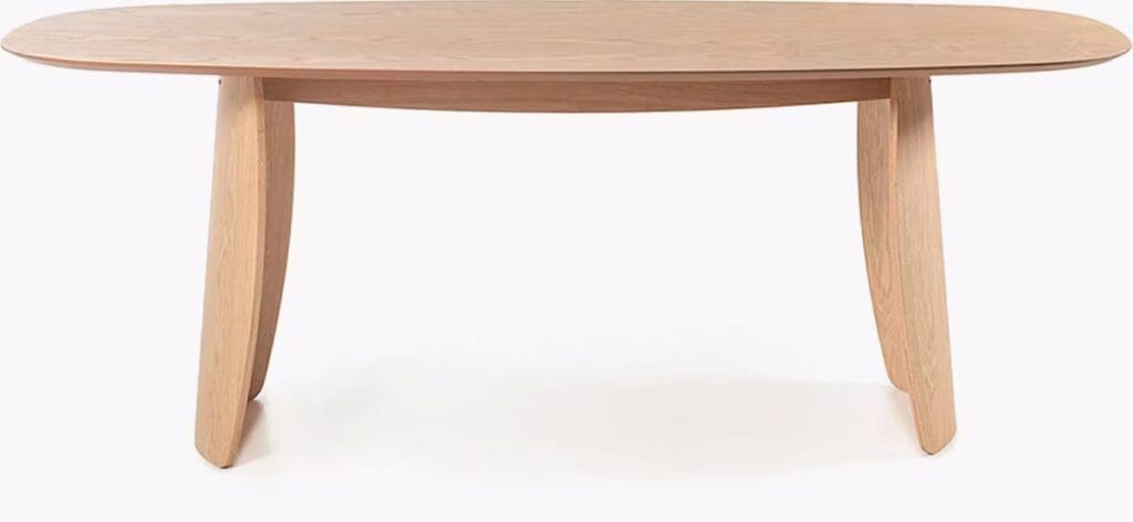 A modern wooden dining table with an oval top and tapered legs.