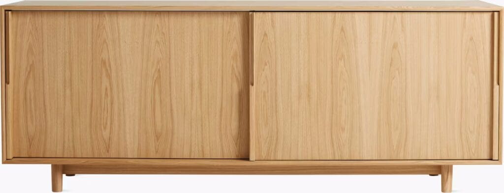 A wooden media cabinet featuring sliding doors and a minimalist design, placed on tapered legs.