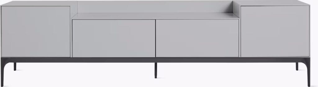 A modern gray media cabinet with sleek lines and a minimalist design, featuring multiple drawers and a raised base.